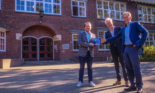 Onderzoeker Wouter Modderkolk (links) overhandigt het eerste exemplaar van het boekje Waarde(n)vol Toetsen op de Vrijeschool aan Gijs van Lennep (rector Stichtse Vrije School) en Allert de Geus (bestuurder van de SGVVS).
