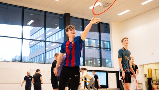 Student Pabo gooit hoepel terwijl medestudenten op de achtergrond andere sportieve dingen doen