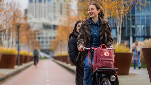 Een student zit achterop de fiets op weg naar Hogeschool Leiden