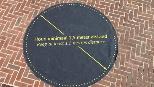 Foto van een mat, waarop staat houd minimaal 1.5 meter afstand