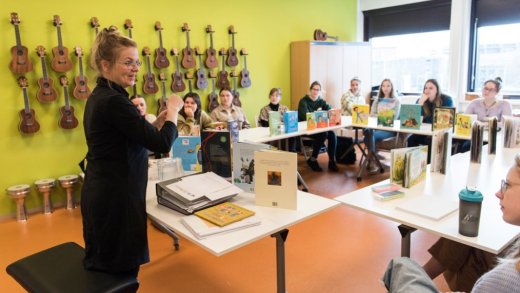Presentatie van Natascha Stenvert aan studenten met verschillende boeken tentoongesteld