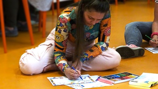 Student zit op de grond en tekent