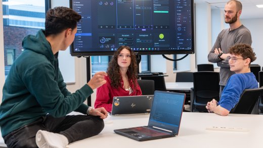 Docent en studenten Informatica aan Hogeschool Leiden bespreken lesstof in de klas