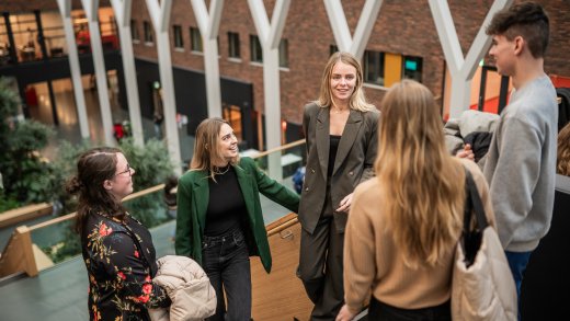 Groepje studenten pratend op trap in hoofdgebouw Hogeschool Leiden