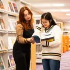 Twee studenten met boek in het Mediacentrum van Hogeschool Leiden