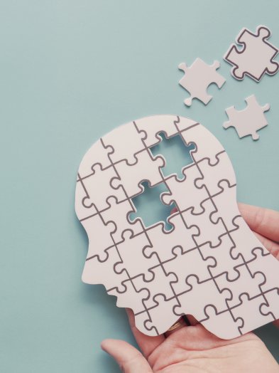 hoofd van puzzelstukjes in handen