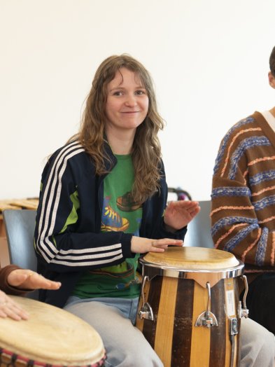 Studenten bespelen diverse slagwerkinstrumenten tijdens een les van muziektherapie