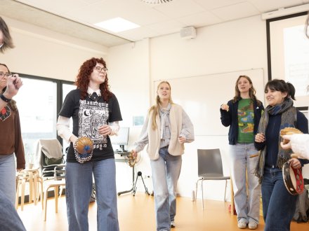 Studenten maken muziek in een kring