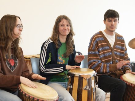 Studenten bespelen diverse slagwerkinstrumenten tijdens een les van muziektherapie