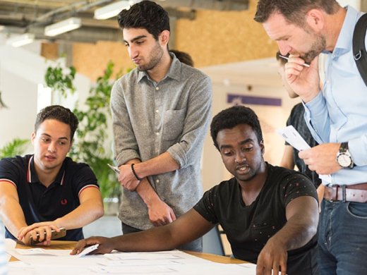 Meerdere studenten hebben een bespreking met een student.