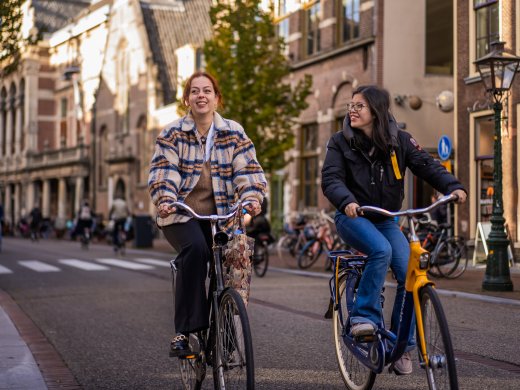 Twee studenten van Hogeschool Leiden fietsen door een typisch stukje Leiden Centrum