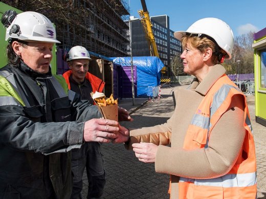 Franziska Brouwer, directeur Facilitair Bedrijf en Huisvesting, deelt patat uit