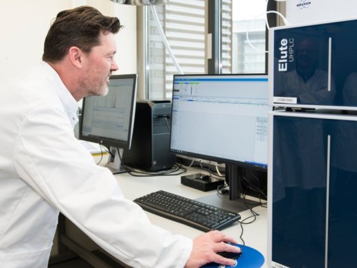 Joeri van den Steenhoven in een labjas achter een computer