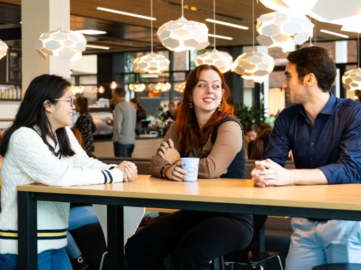 Drie studenten praten gezellig in restaurant Fresco