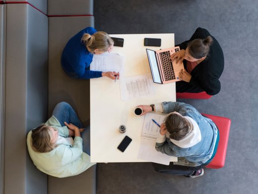 Vier studenten studeren aan een tafel
