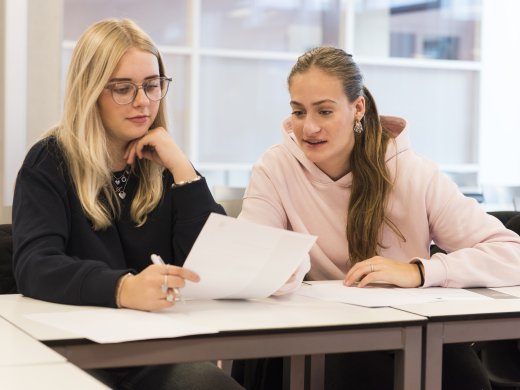 Twee studenten aan een tafel in een klaslokaal