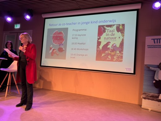 Directeur Dorothee van Kammen van Thomas  More Hogeschool met microfoon op podium bij symposium Taal in de Natuur op 17 maart 2025 in Rotterdam
