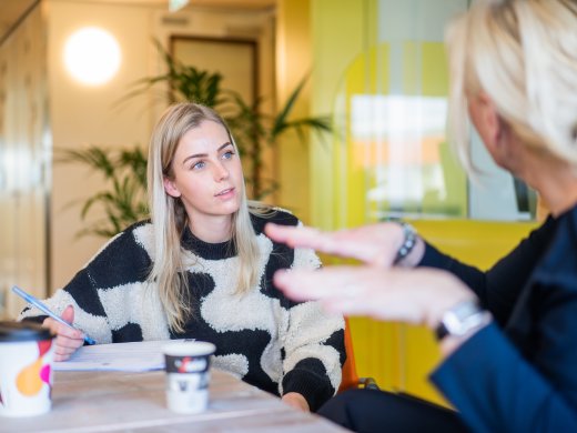 Jonge zorgprofessional luisterend naar vrouw
