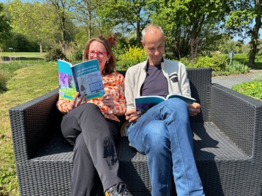 Schrijvers van het boek op een bank