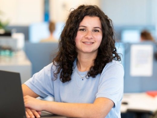Een foto van Noa achter haar laptop