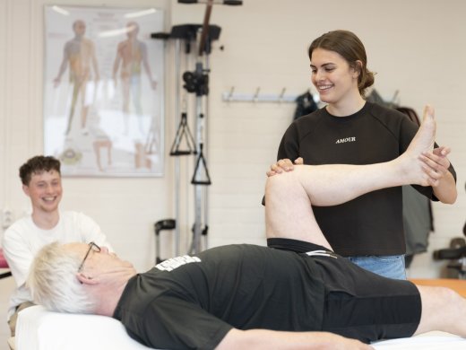 Een student Fysiotherapie begeleidt een simulant.