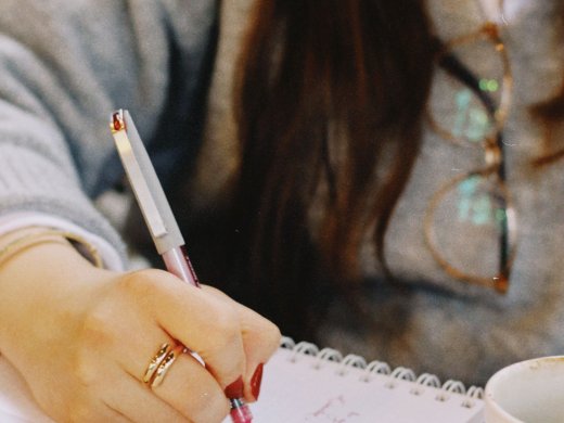 student schrijft met pen in schrift
