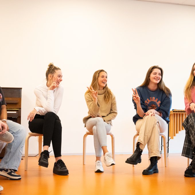 Studenten vaktherapie zitten in kring en doen peaceteken
