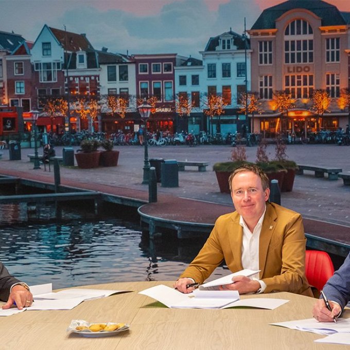 Sander van den Eijnden, Marco Peppel en Mark van Wordragen aan tafel papieren aan het ondertekenen