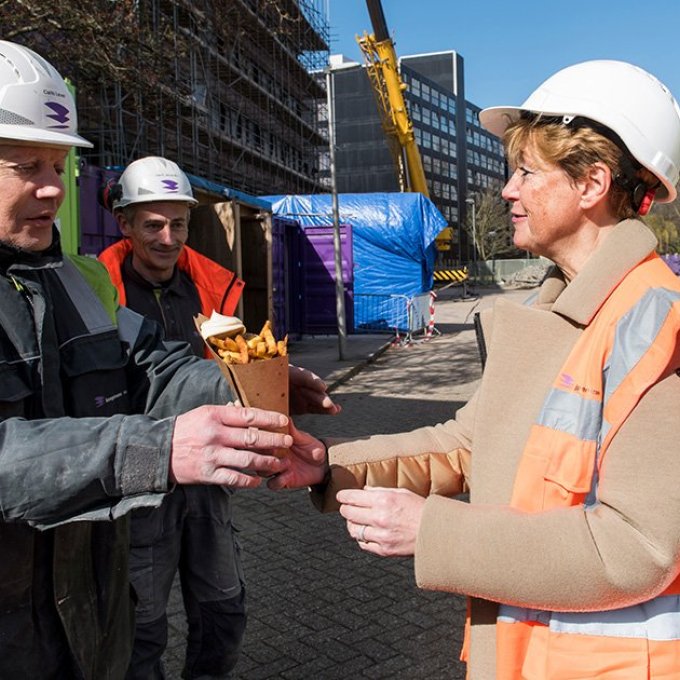 Franziska Brouwer, directeur Facilitair Bedrijf en Huisvesting, deelt patat uit