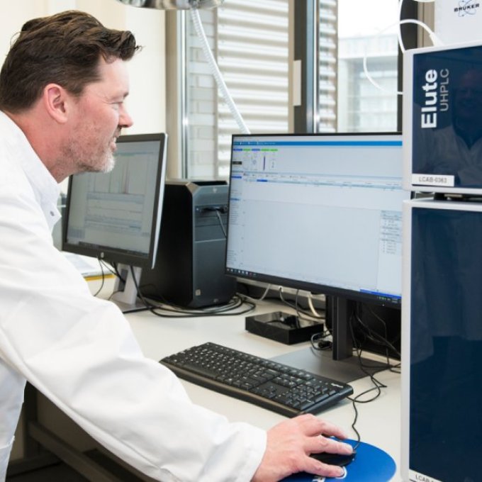 Joeri van den Steenhoven in een labjas achter een computer