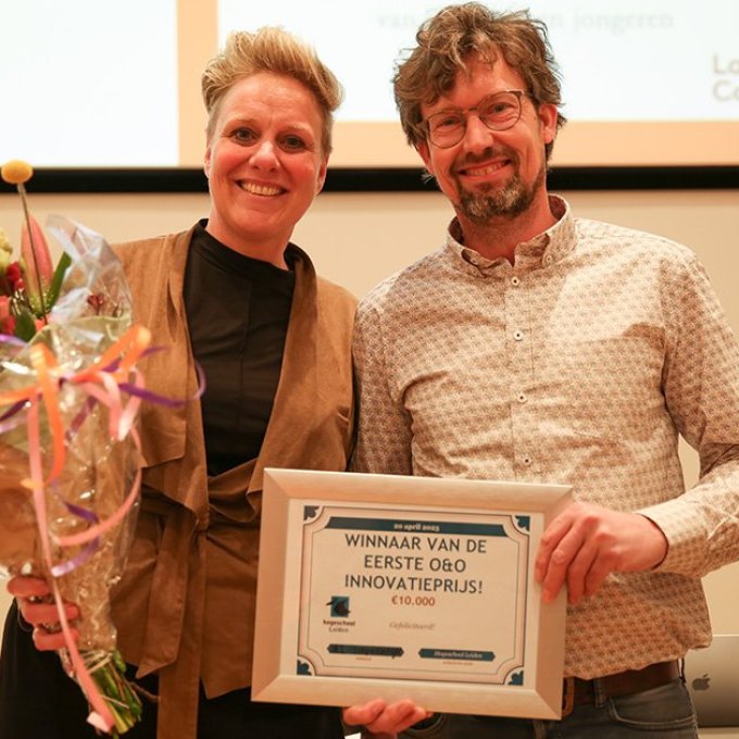 Suzanne de Groot (Management in de Zorg) en Roland Westveer (Informatica) met het gewonnen certificaat en een bos bloemen