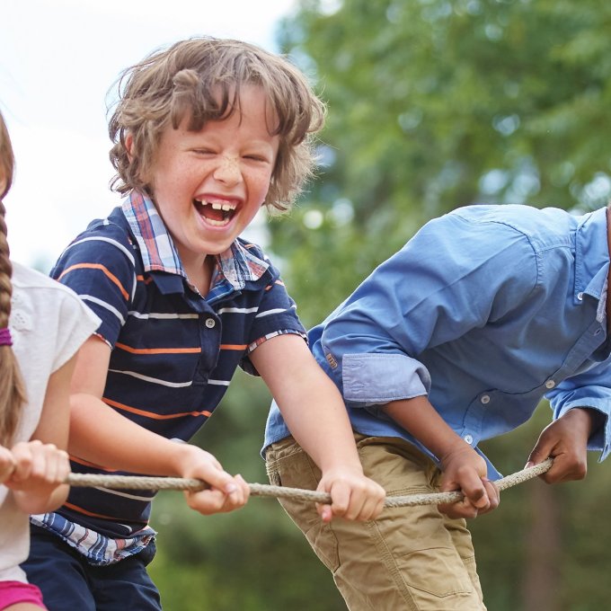 vier lachende kleine kinderen houden touw vast