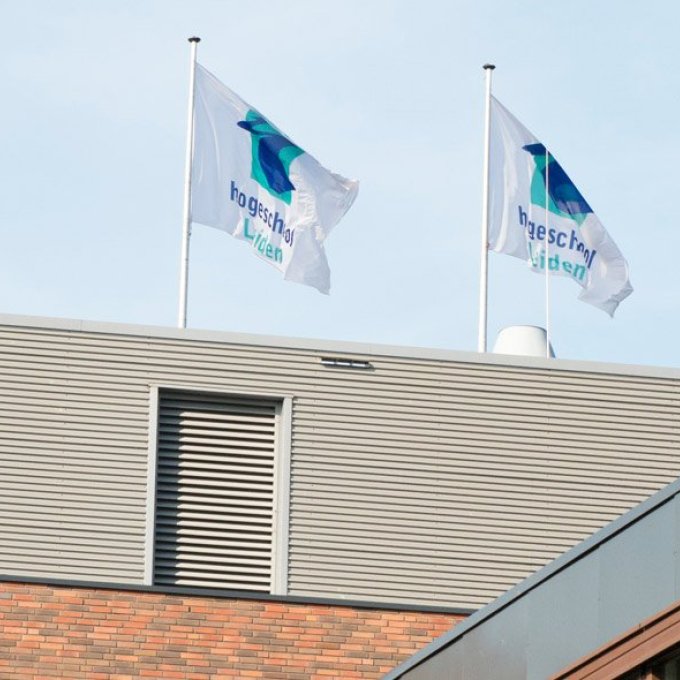 foto van drie vlaggen op het dak van Hogeschool Leiden