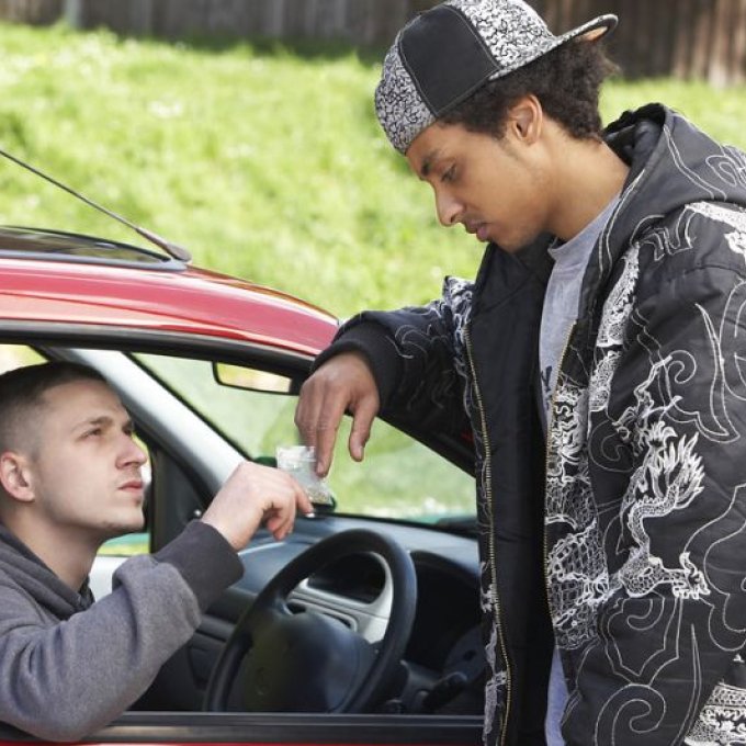 Twee jongeren die in drugs dealen vanuit een rode auto