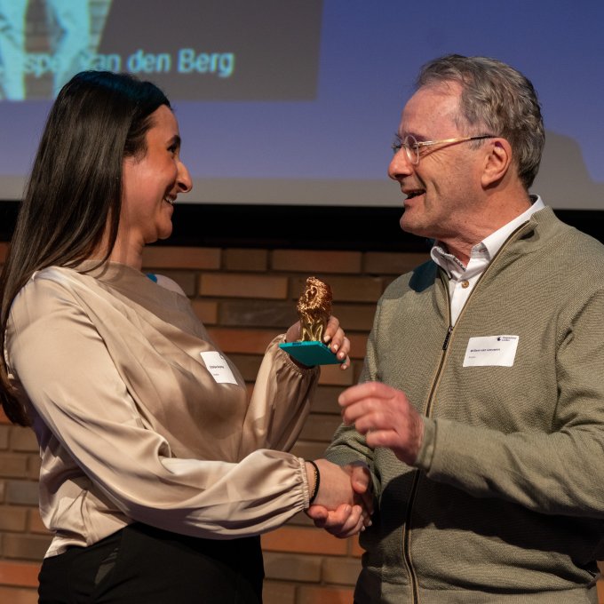 Estelya Deymez, winnaar van de Willem van Leeuwen prijs, schudt hand met Willem van Leeuwen