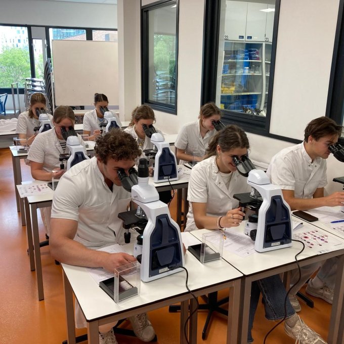Geneeskundestudenten achter een microscoop