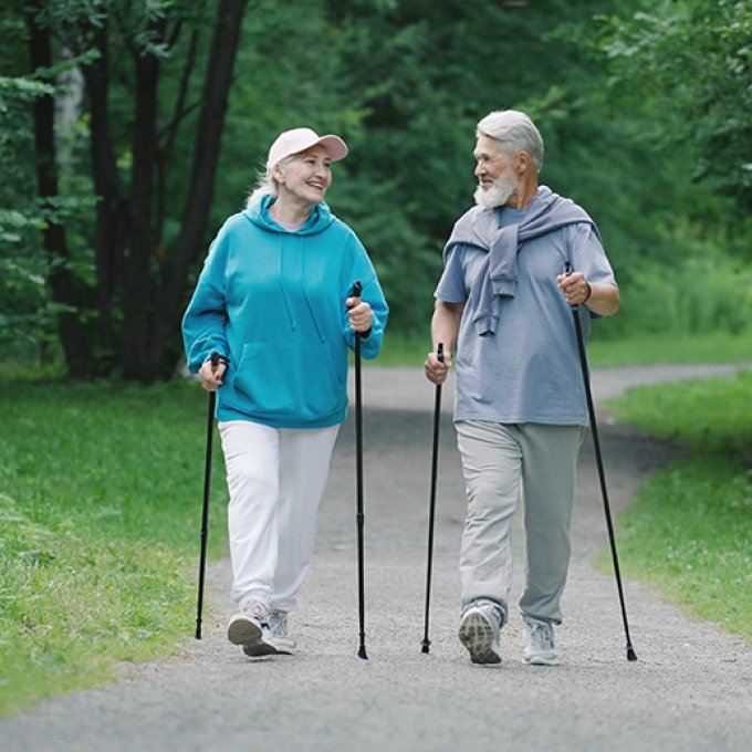 twee personen wandelend met nordic walking stokken
