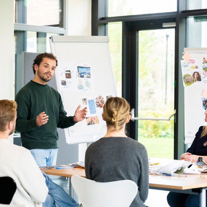 Een persoon geeft les voor een klas met studenten.