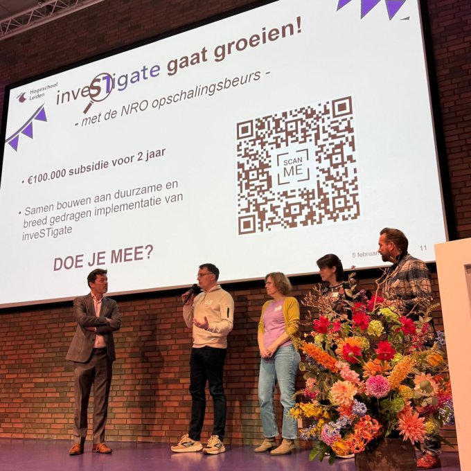 Joeri van den Steenhoven en docenten van de opleiding Bio-Informatica staan op een podium. Zij geven een praatje over Investigate en de NRO opschalingsbeurs